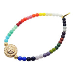 Dana Levy Multicolored Rainbow beaded bracelet with a gold sun charm on a white background.
