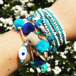 Dana Levy Azure Pompom Lucky Charms Leather Cord Bracelet - on wrist with friendship bracelets