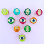 Dana Levy Neon Evil Eye Charm Ring - With Neon Hamsa Hand Rings on Pink Background