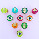 Dana Levy Neon Evil Eye Charm Ring - With Neon Hamsa Hand Rings on Pink Background