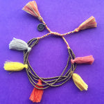 Dana Levy Multi Tassel Bead Drawstring Bracelet - Yellow Mix on Purple Background