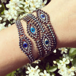 Dana Levy Mother of Pearl Evil Eye Charm Swarovski Crystal Ball Chain Bracelet - All Crystal Combinations on Wrist Floral Background