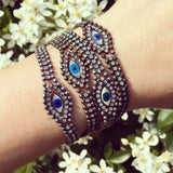 Dana Levy Mother of Pearl Evil Eye Charm Swarovski Crystal Ball Chain Bracelet - All Crystal Combinations on Wrist Floral Background