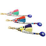 Dana Levy Personalised Alphabet Cube Evil Eye Charm Tassel Keyring - A Trio of Gold Plated Keyrings with Love Nest, Eye Candy and Protect Written with Alphabet Letter Cubes and Decorated with Evil Eye Charms and Colourful Tassels.