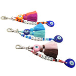 Dana Levy Personalised Alphabet Cube Evil Eye Charm Tassel Keyring - A Trio of Silver Plated Keyrings with Happy Home and Love Spelled out With White Acrylic Letter Cube Beads, Glass Candy Beads and Decorated With Evil Eye Amulets and Double Tassels in a Variety of Colours.  