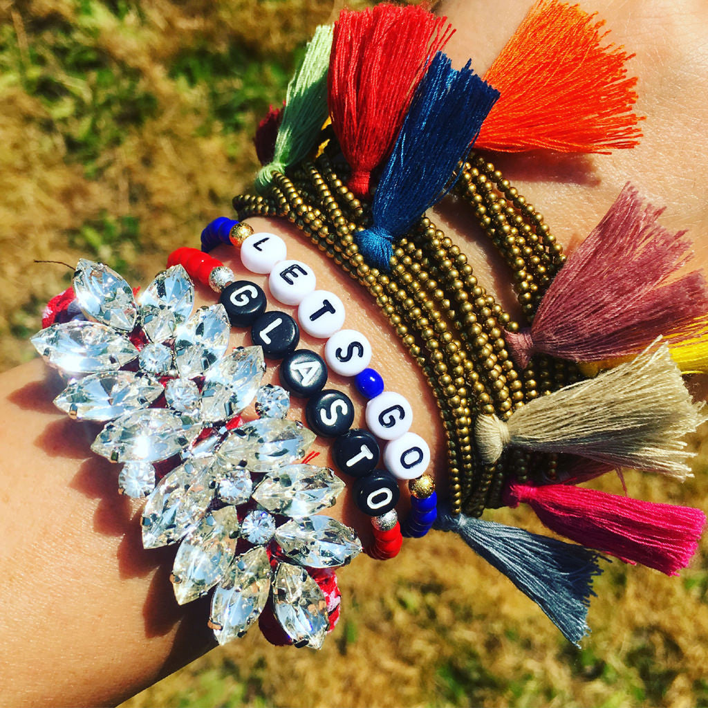 Dana Levy custom name glass Bead bracelets  that read Lets Go Glasto with friendship bracelets on a wrist. 