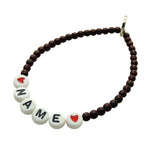 Dana Levy Personalised Name Alphabet Glass Bead Bracelet - Name in white alphabet letters with Red Hearts and maroon glass beads on a white background. 