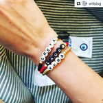 Dana Levy personalised name bracelets on a wrist with Greta, Laura and Vera names in various colours.