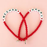 Dana Levy personalised name bead bracelets in a heart shape with Meghan and Harry in red beads with red hearts.  