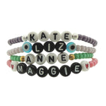 Dana Levy personalised name bracelets with pastel coloured glass beads and girls names in acrylic letter beads on a white background.