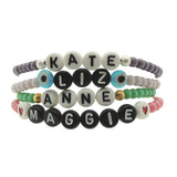 Dana Levy personalised name bracelets with pastel coloured glass beads and girls names in acrylic letter beads on a white background.